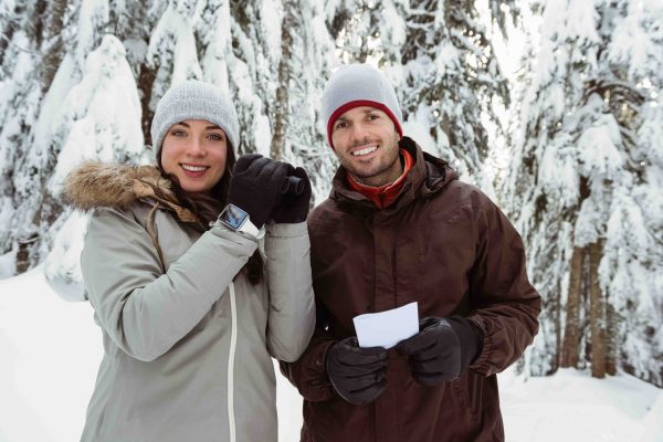 skier-couple-holding-binocular-and-address-card-on-snow-covered-mountain (1)-compressed